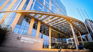 A modern building with a glass facade and a curved entrance canopy. - InterContinental Beijing Beichen by IHG (Beijing)