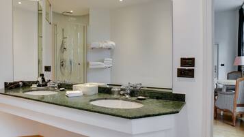 Un baño moderno con dos lavamanos, un espejo grande y una ducha.