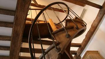 A wooden spiral staircase with metal railings and a wooden handrail.