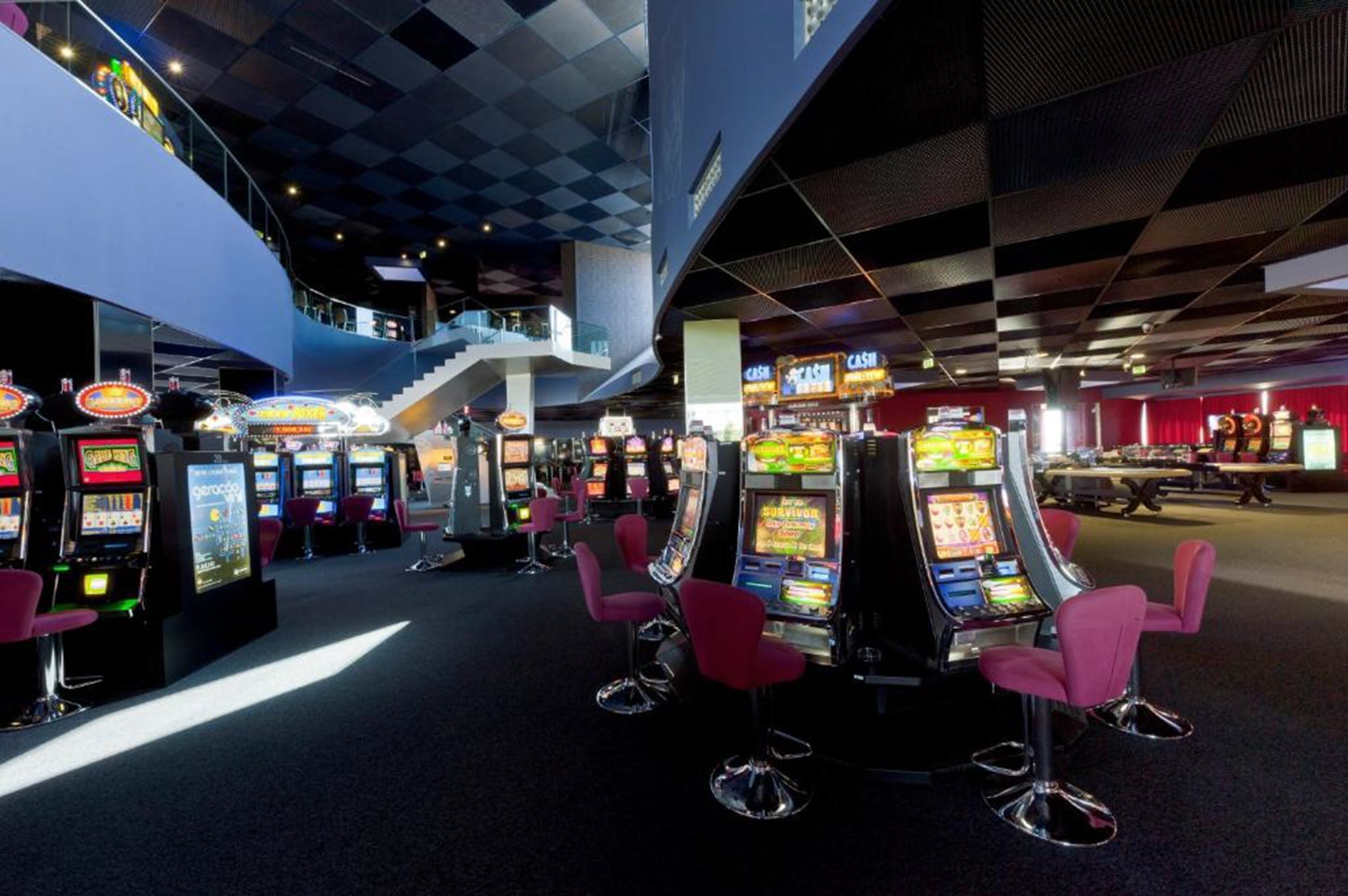 A casino interior with slot machines and a staircase.
