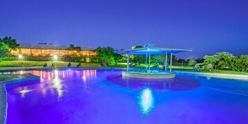 Una piscina al aire libre, sillones reclinables de piscina