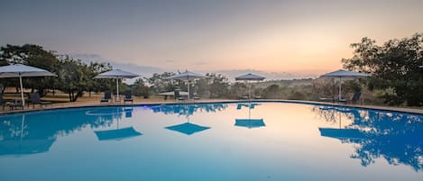 Una piscina al aire libre, tumbonas