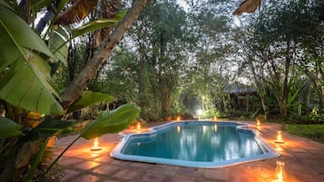 Alberca al aire libre, sombrillas en la alberca y camastros