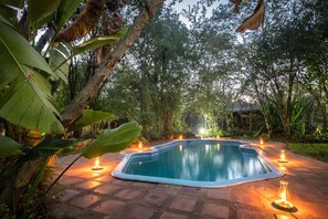 A rectangular swimming pool with a tiled edge, surrounded by a brick pathway. - Taita Falcon Lodge (Livingstone)