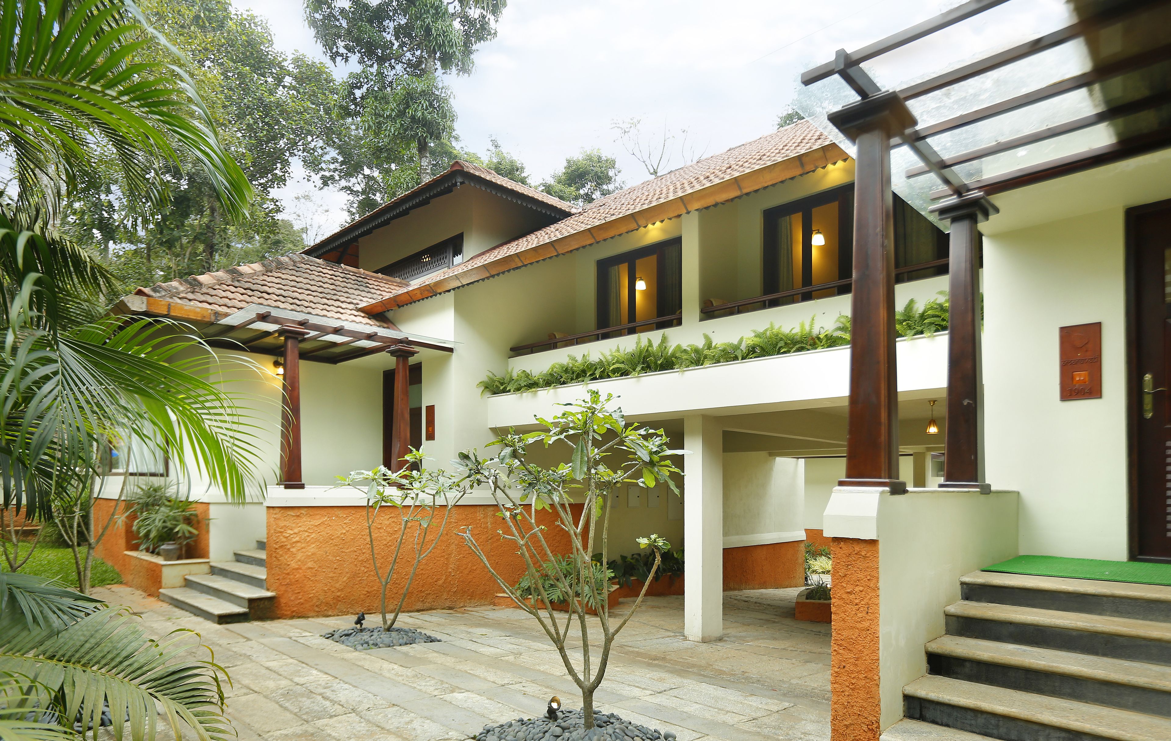 A two-story building with a tiled roof, a balcony, and a staircase leading to the upper floor.
