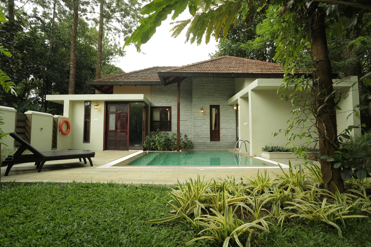 Una casa moderna con piscina, una tumbona y un flotador.