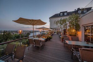 An outdoor terrace with tables and chairs, umbrellas, and potted plants. - Hotel Schöne Aussicht (Frankfurt)