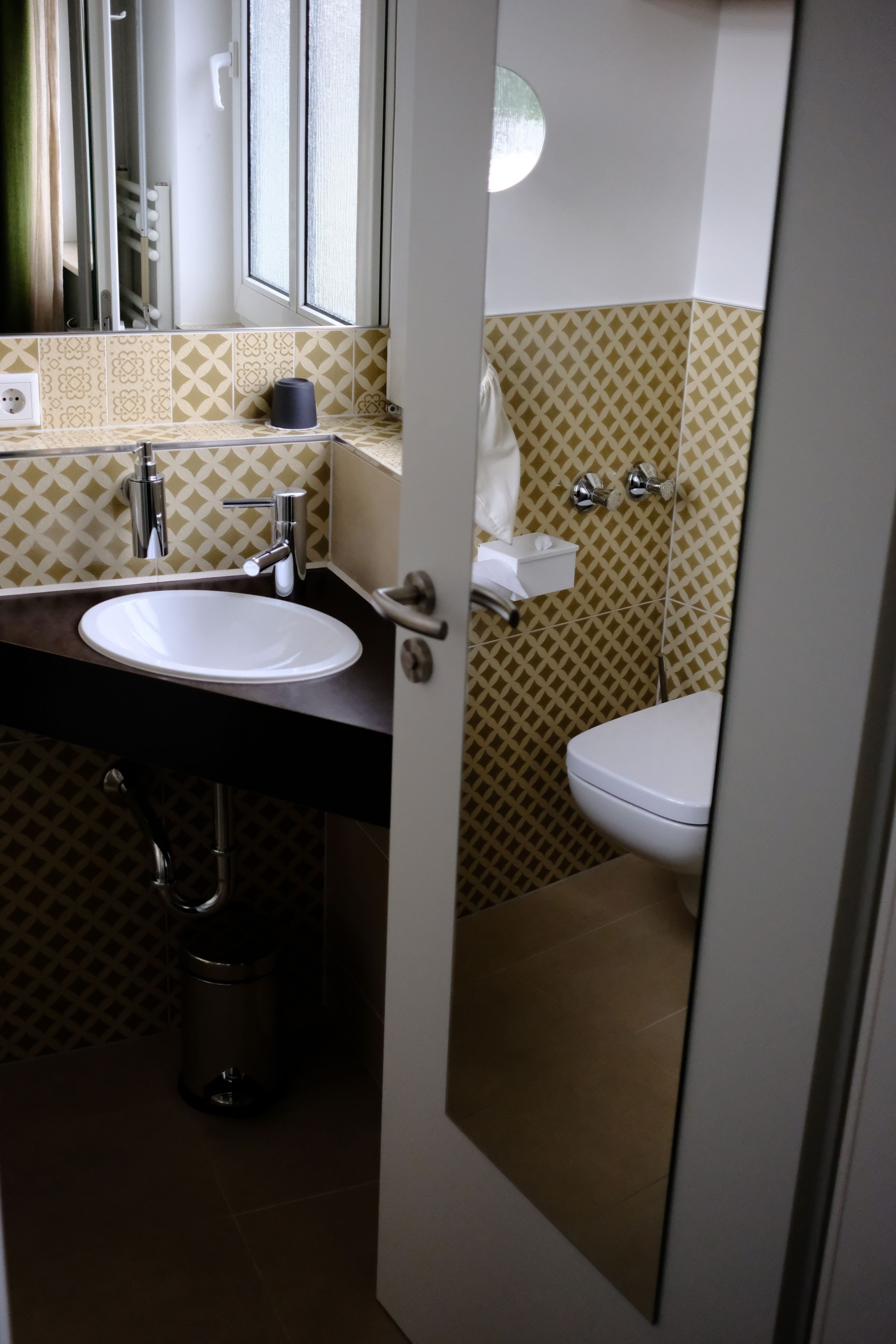 Une salle de bain avec un lavabo blanc, un miroir et des toilettes.