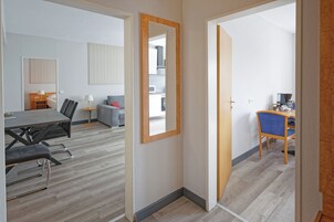 A hotel room with a dining area, a kitchen, and a living space.