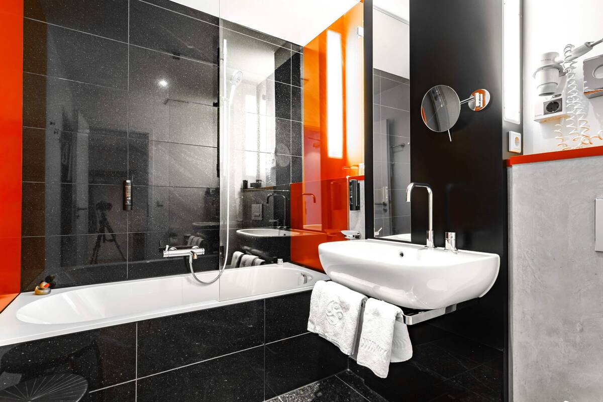 A modern bathroom with a bathtub, a sink, and a mirror.