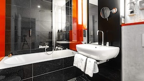 Un bany modern amb una banyera gran, un lavabo i un mirall.