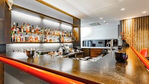 En bardisk med en elegant träinredning, ett stort urval av spritflaskor och en modern inredningsstil.