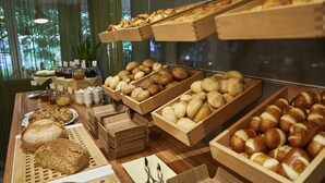A bakery display with various breads and pastries in wooden trays. - Hotel Ritter Durbach (Durbach)