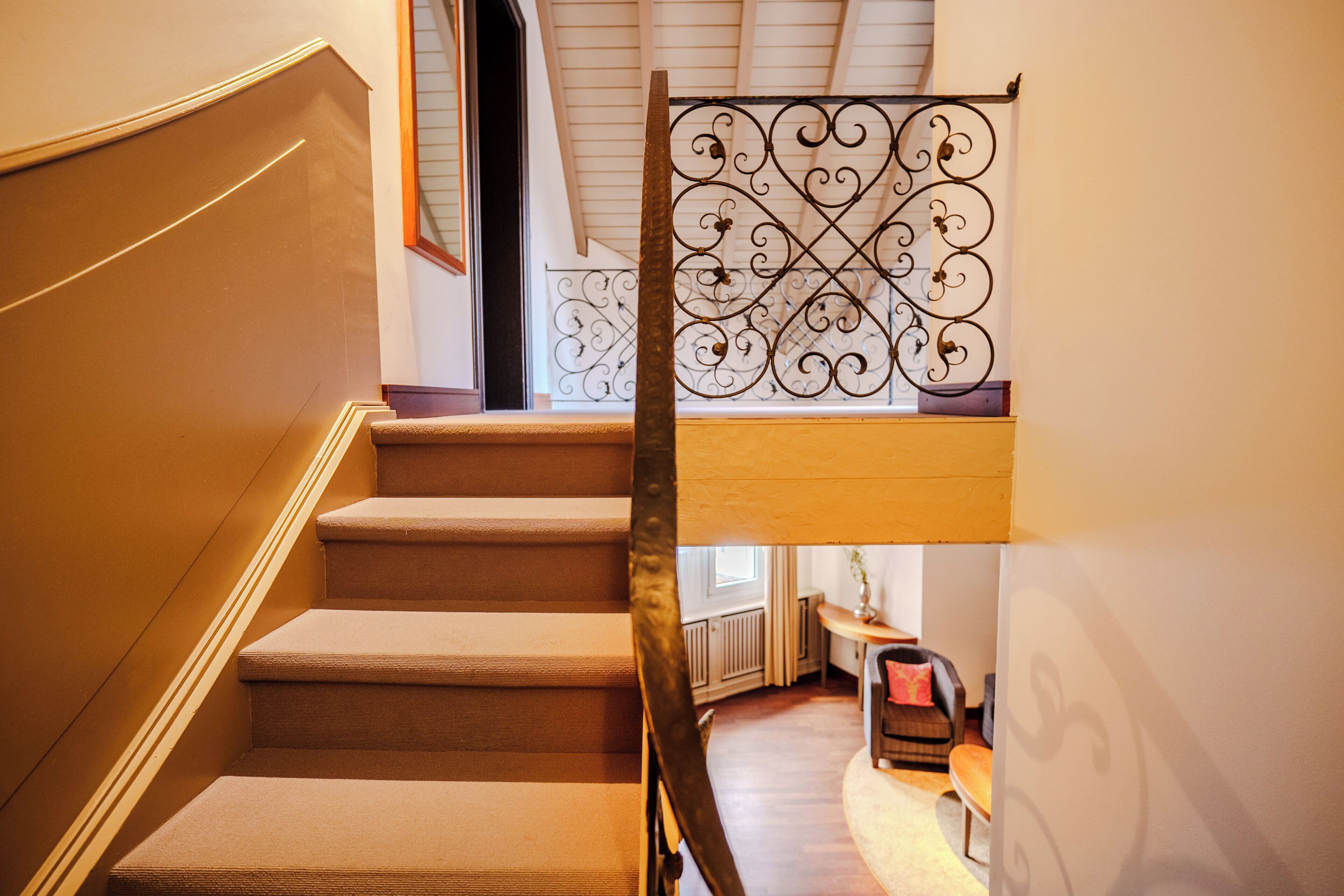 A staircase with a metal railing and carpeted steps.