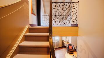 A staircase with a metal railing and carpeted steps.