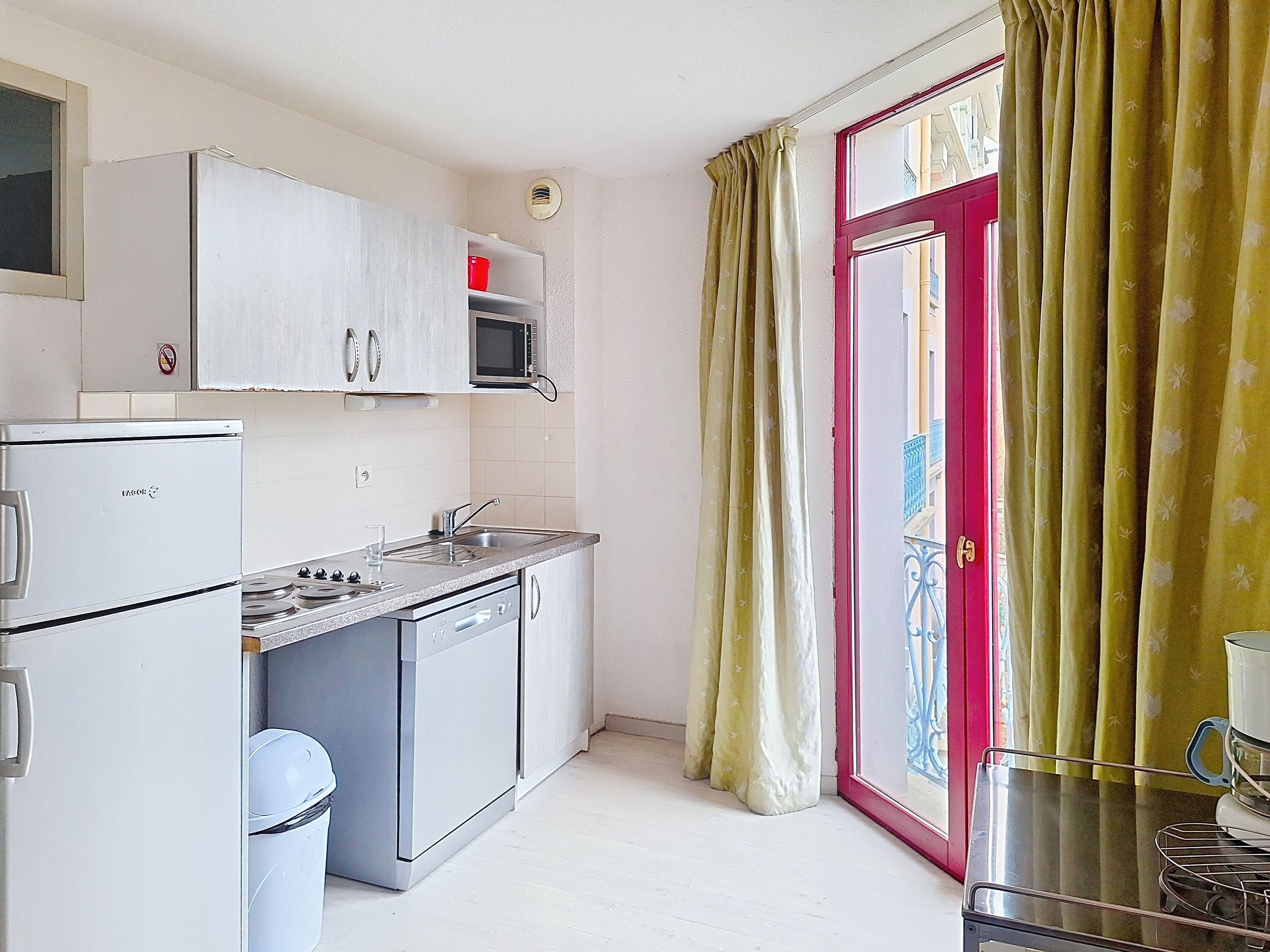 A compact kitchen with a refrigerator, microwave, sink, and stove.