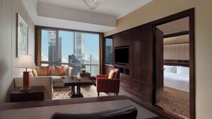 A hotel room with a large window, a sofa, a chair, a TV, and a bed. - Futian Shangri-La Shenzhen (Shenzhen)