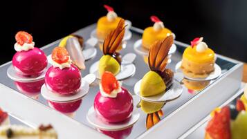 A variety of colorful desserts arranged on a reflective surface.