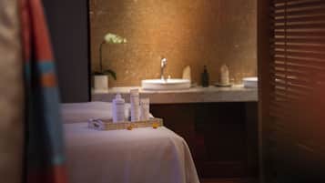 A hotel bathroom with a sink, toiletries, and a mirror.