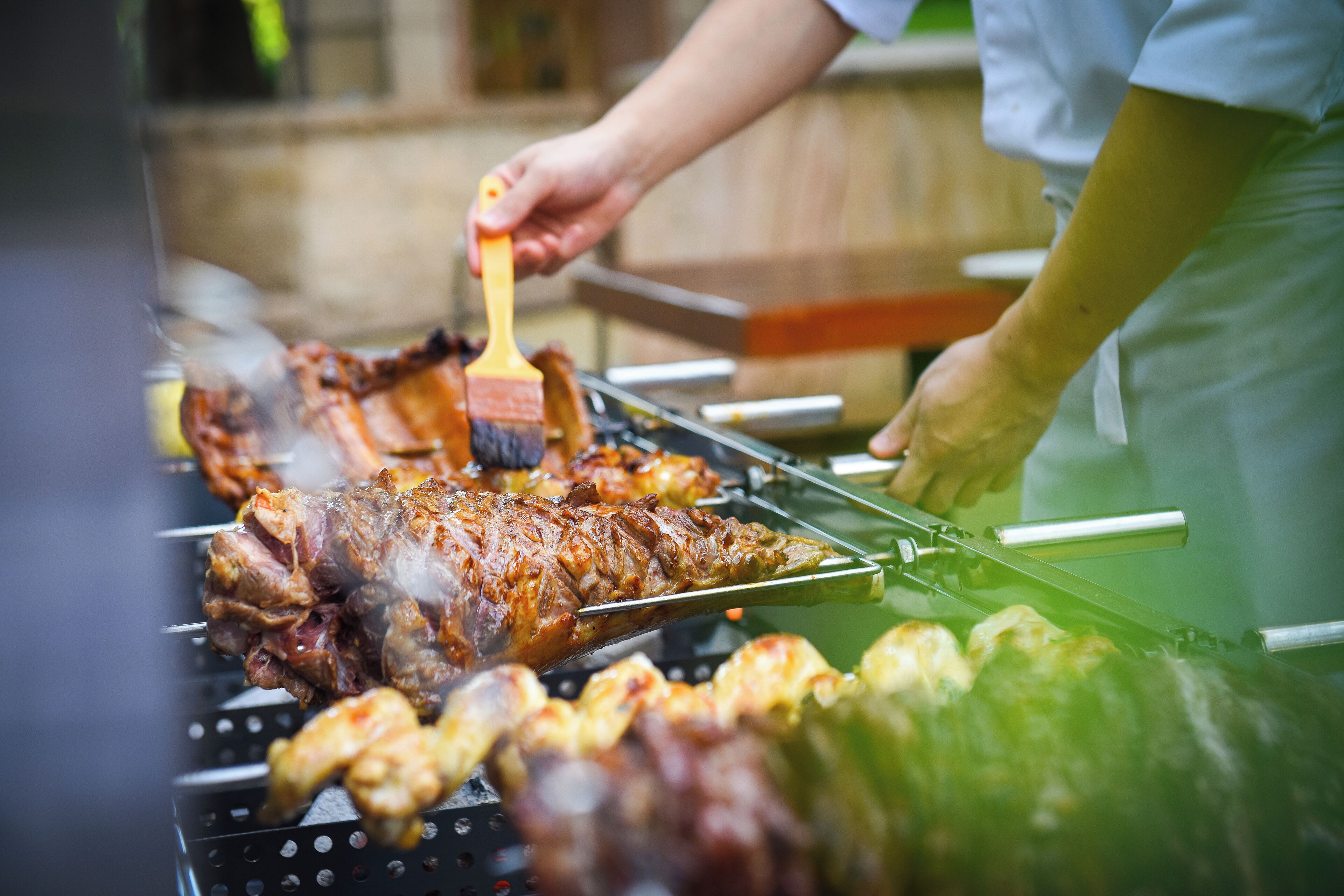 Una persona asando carne en una barbacoa.