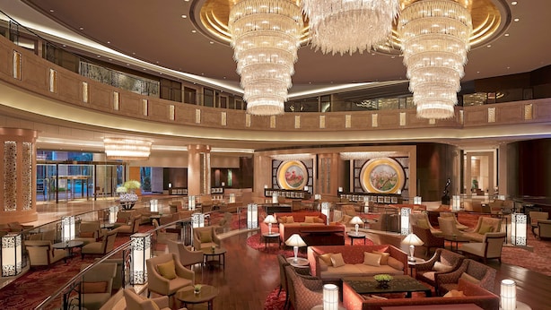 A spacious lobby with multiple seating areas, large chandeliers, and decorative wall panels. - Futian Shangri-La Shenzhen (Shenzhen)