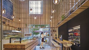 A modern café interior with wooden furniture, hanging pendant lights, and a visible menu board. - Futian Shangri-La Shenzhen (Shenzhen)