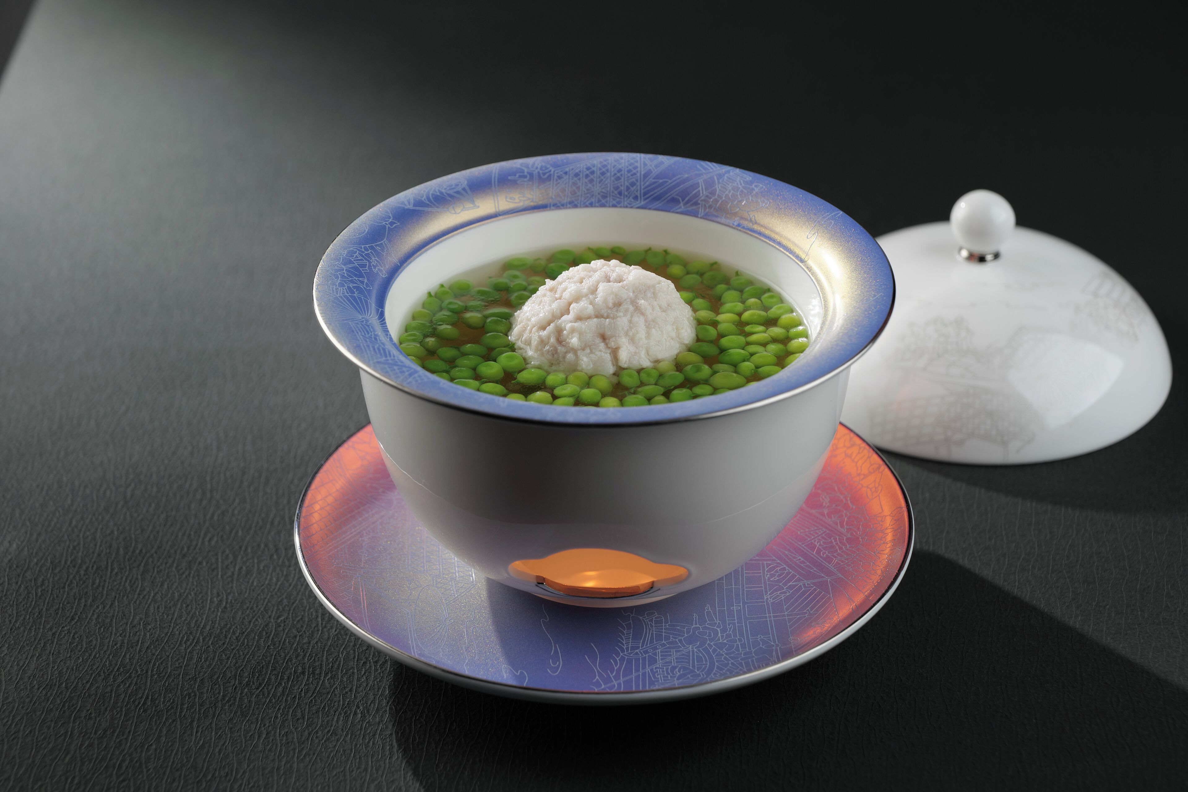 Un tazón de arroz y guisantes verdes con una tapa sobre una mesa.