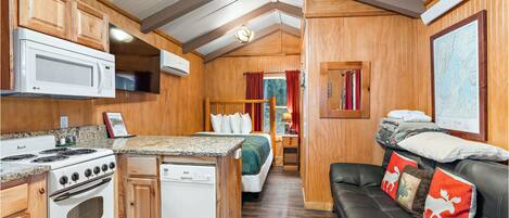 A compact RV kitchen with a stove, microwave, and dishwasher.