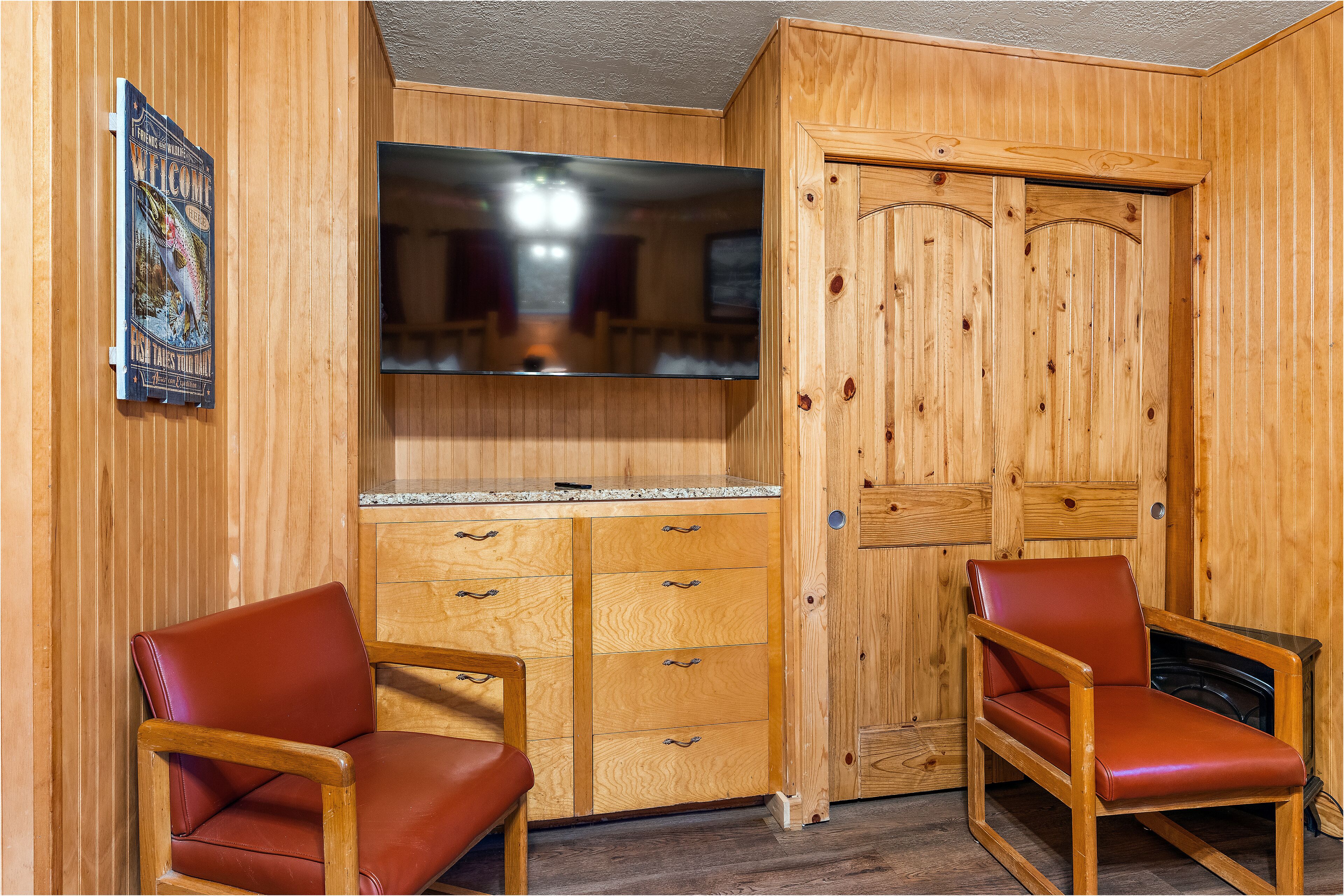 Un interior de madera con dos sillones de cuero, un mueble de madera con cajones y un espejo grande.