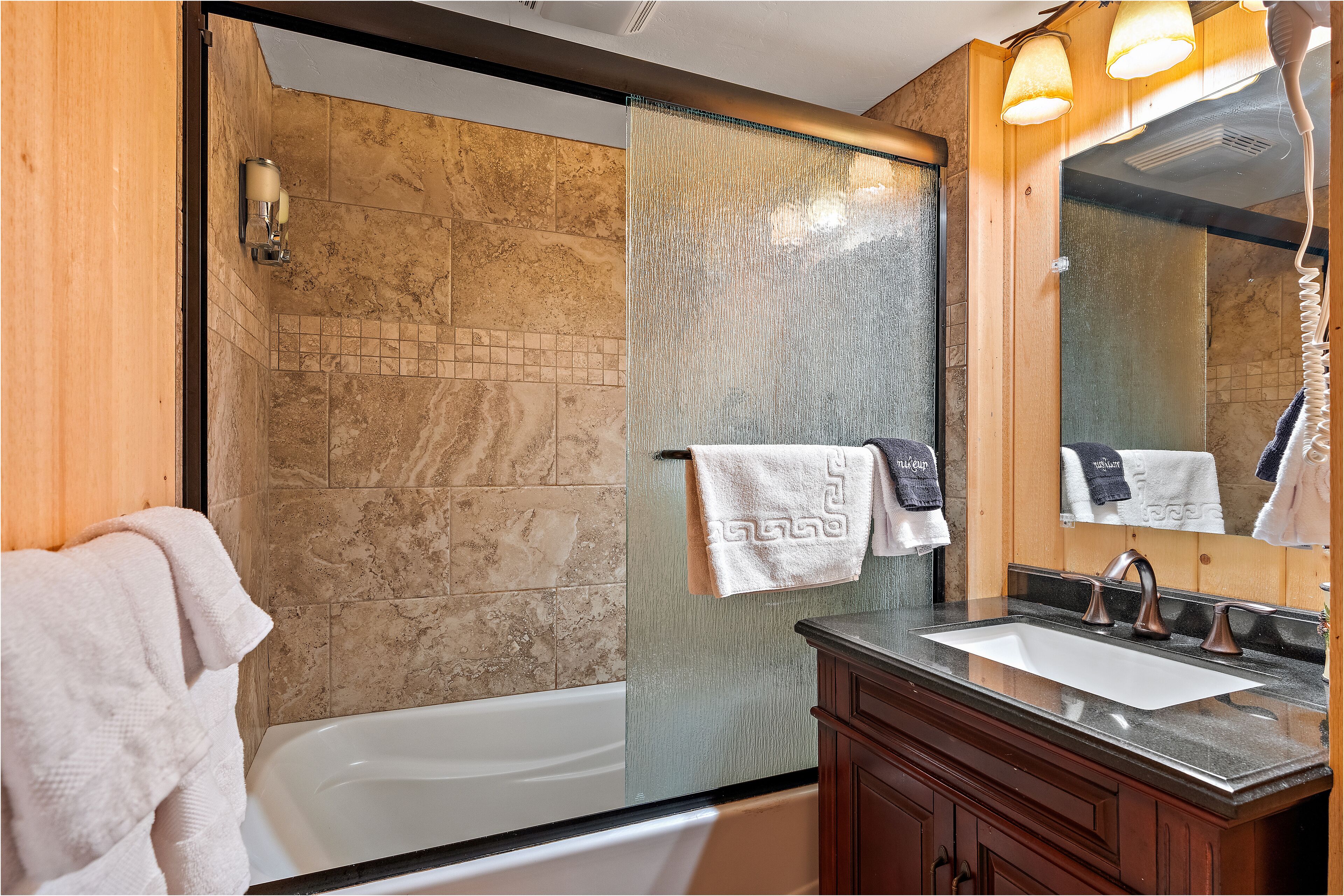 A bathroom with a bathtub, a sink, and a mirror.