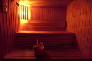 A sauna with wooden benches and a single bucket on the floor. - Résidence Lagrange Vacances Le Grand Panorama II (Valmeinier)