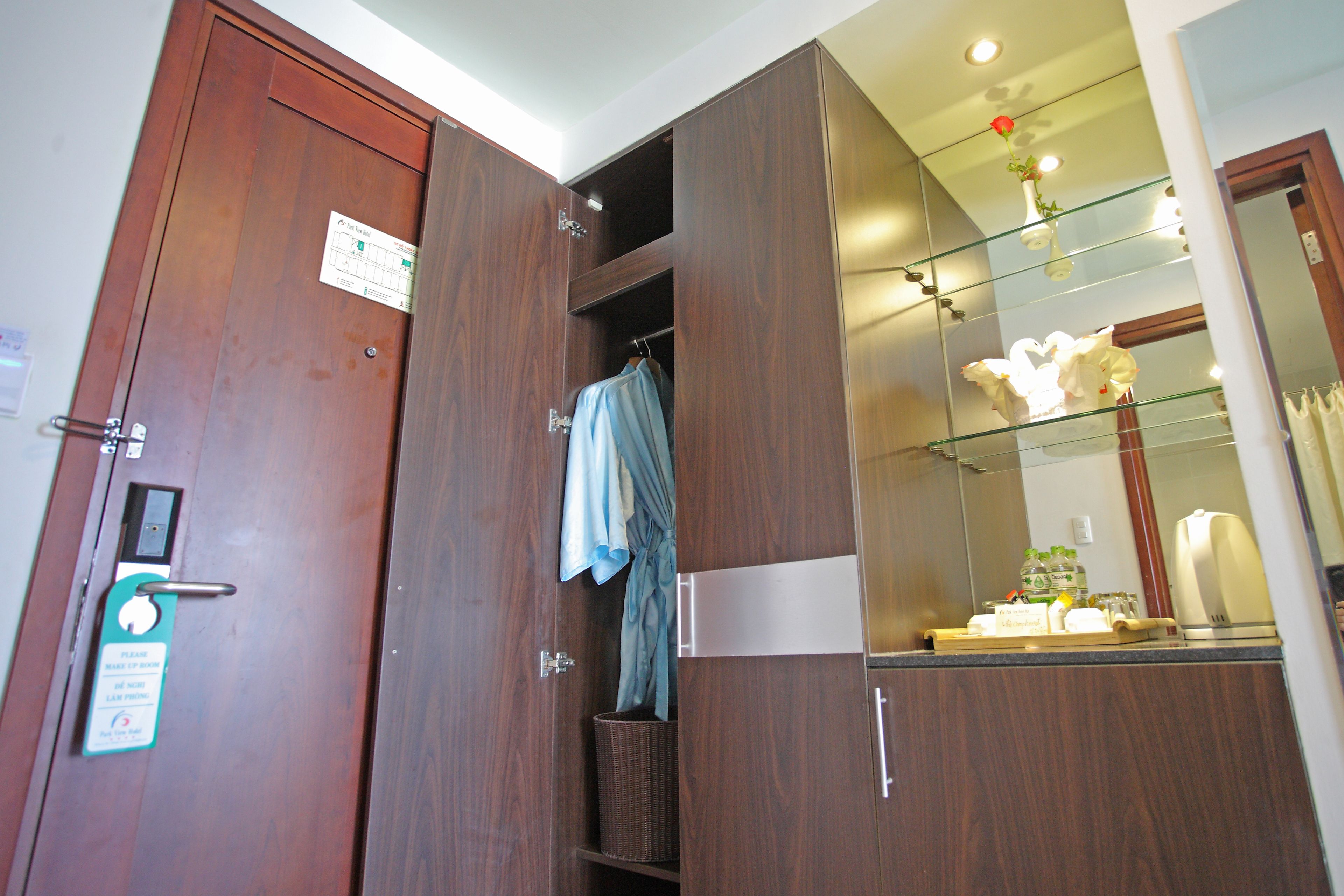 A wooden wardrobe with a mirror and a small shelf.
