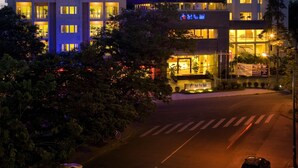A multi-story hotel with illuminated windows and a well-lit entrance. - ParkView Hotel (Hue)