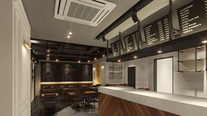 A modern coffee shop interior with a counter, seating area, and menu boards. - Hotel Kobos (Seoul)