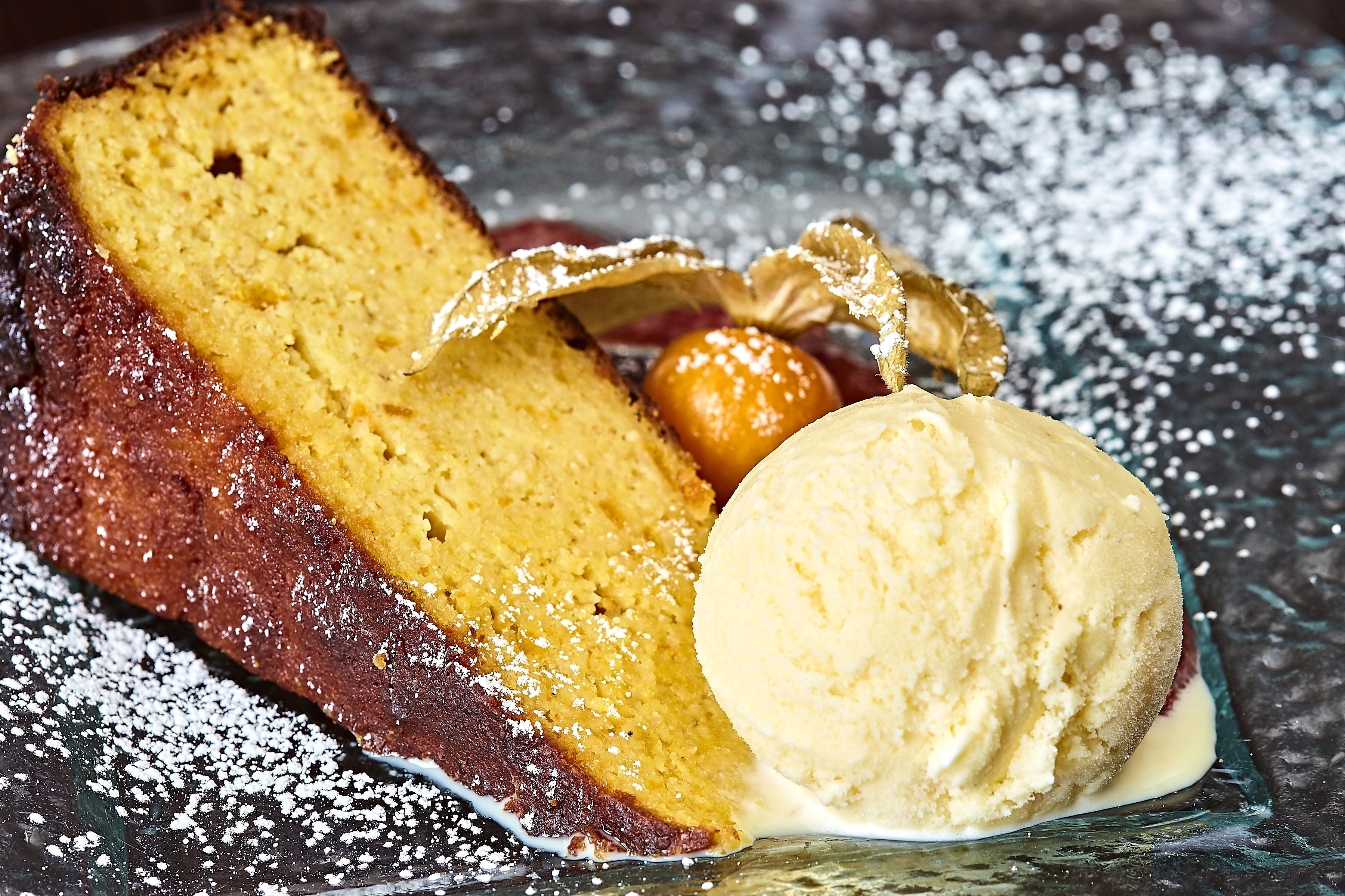 A dessert with a slice of cake and a scoop of ice cream on a plate.
