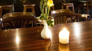 Un bar con mobiliario de madera, una barra y una variedad de botellas y vasos.