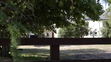 Uma área cercada com um edifício ao fundo.