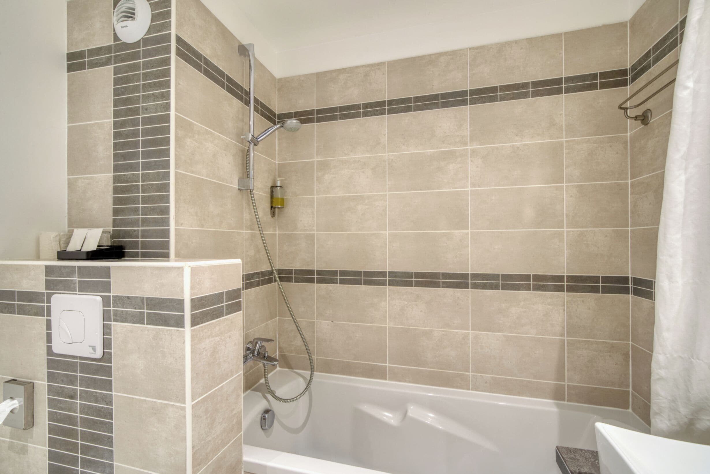 Ein Badezimmer mit Badewanne, Dusche und Handtuchhalter.