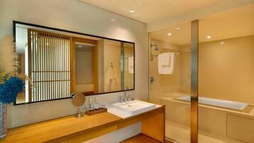A modern bathroom with a large mirror, wooden vanity, and a glass-enclosed shower.