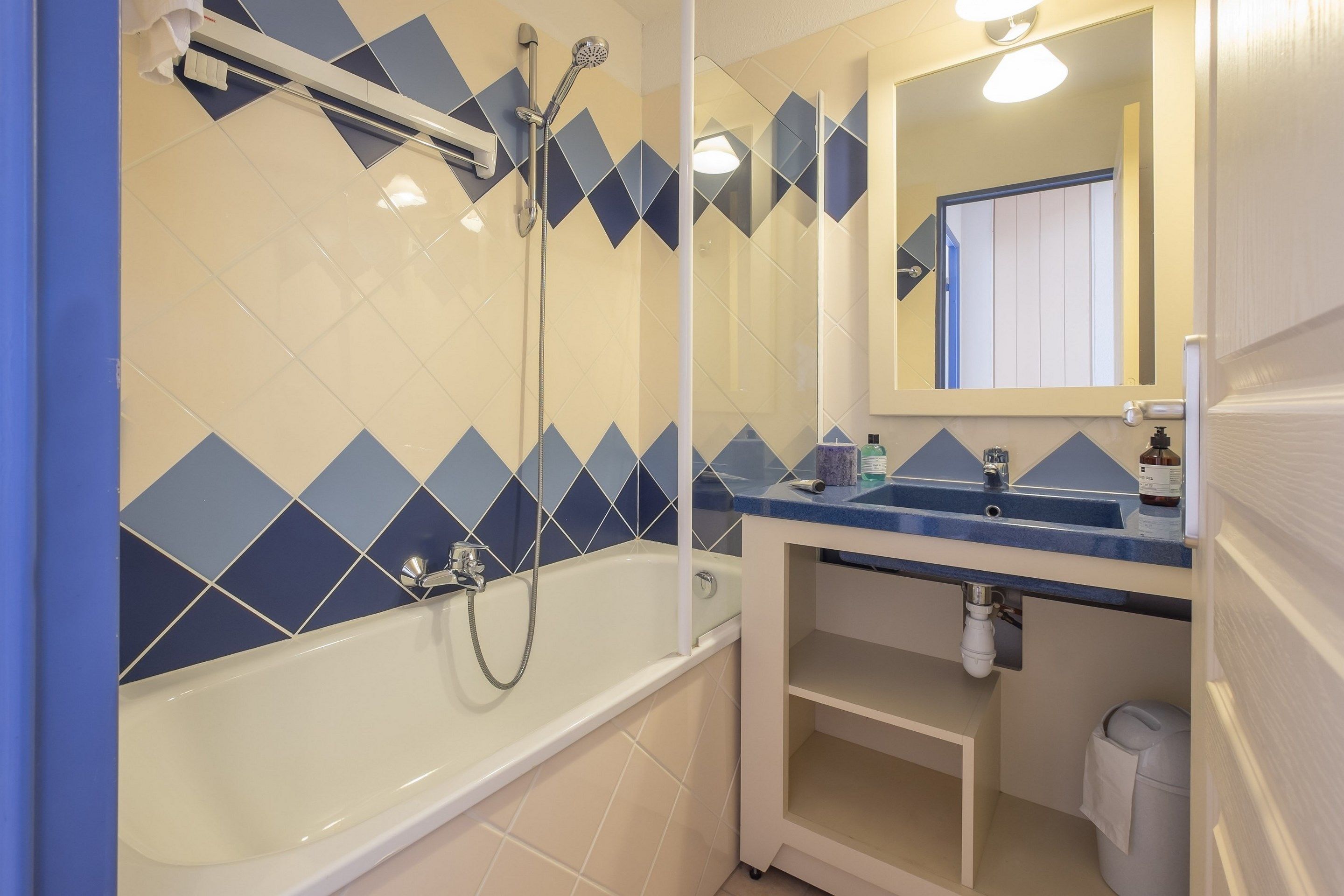 Un baño con bañera, ducha, lavabo y espejo.