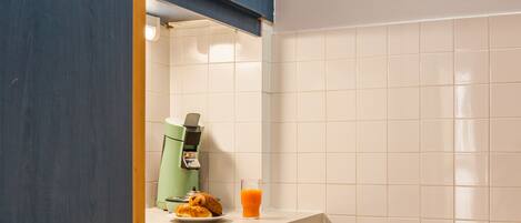A kitchen with a built-in oven, a coffee maker, and a plate of food on the counter.