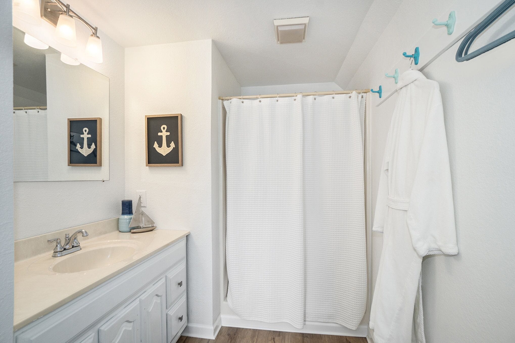 A bathroom with a sink, mirror, and shower curtain.