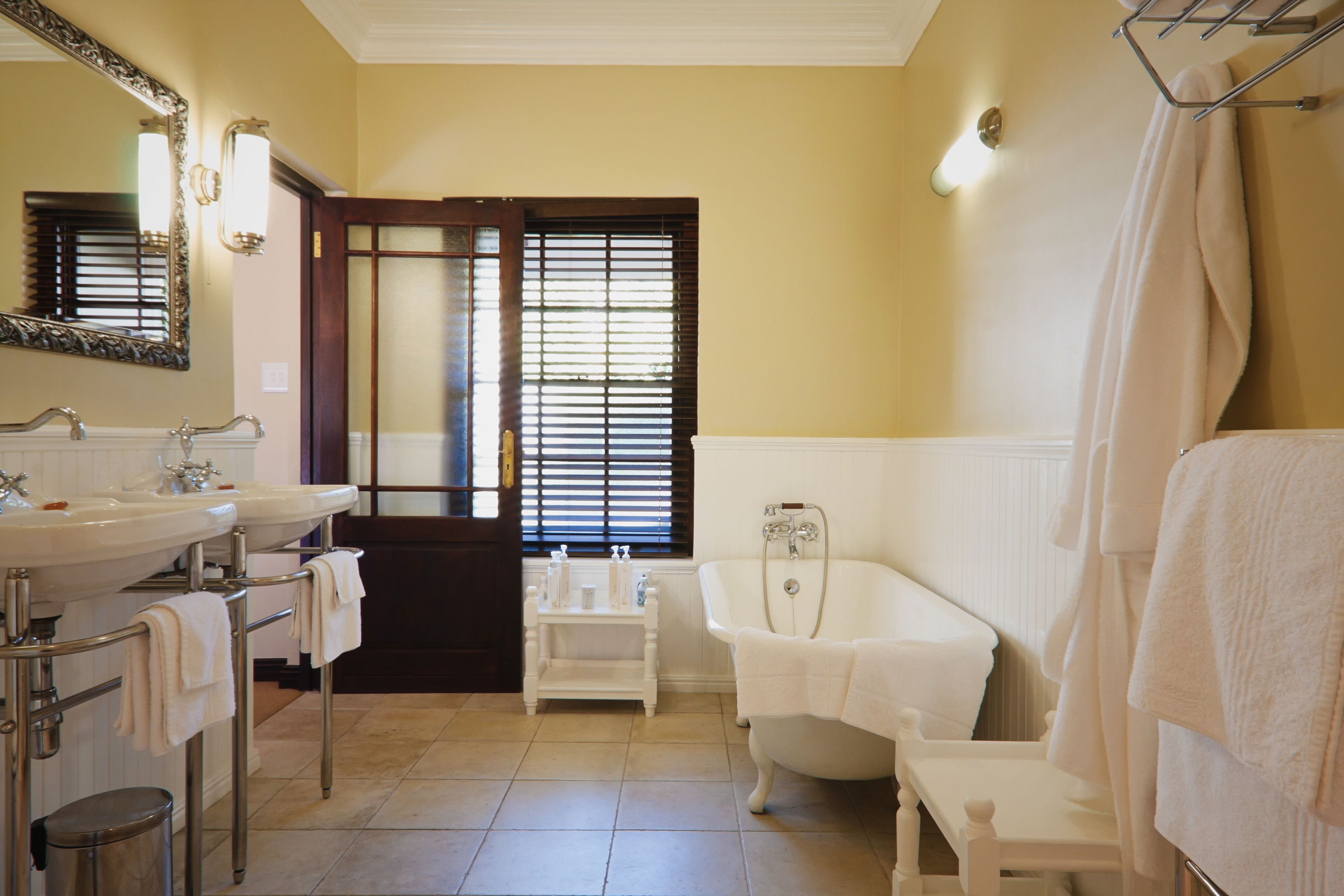 Un baño con dos lavamanos, una bañera y un espejo.