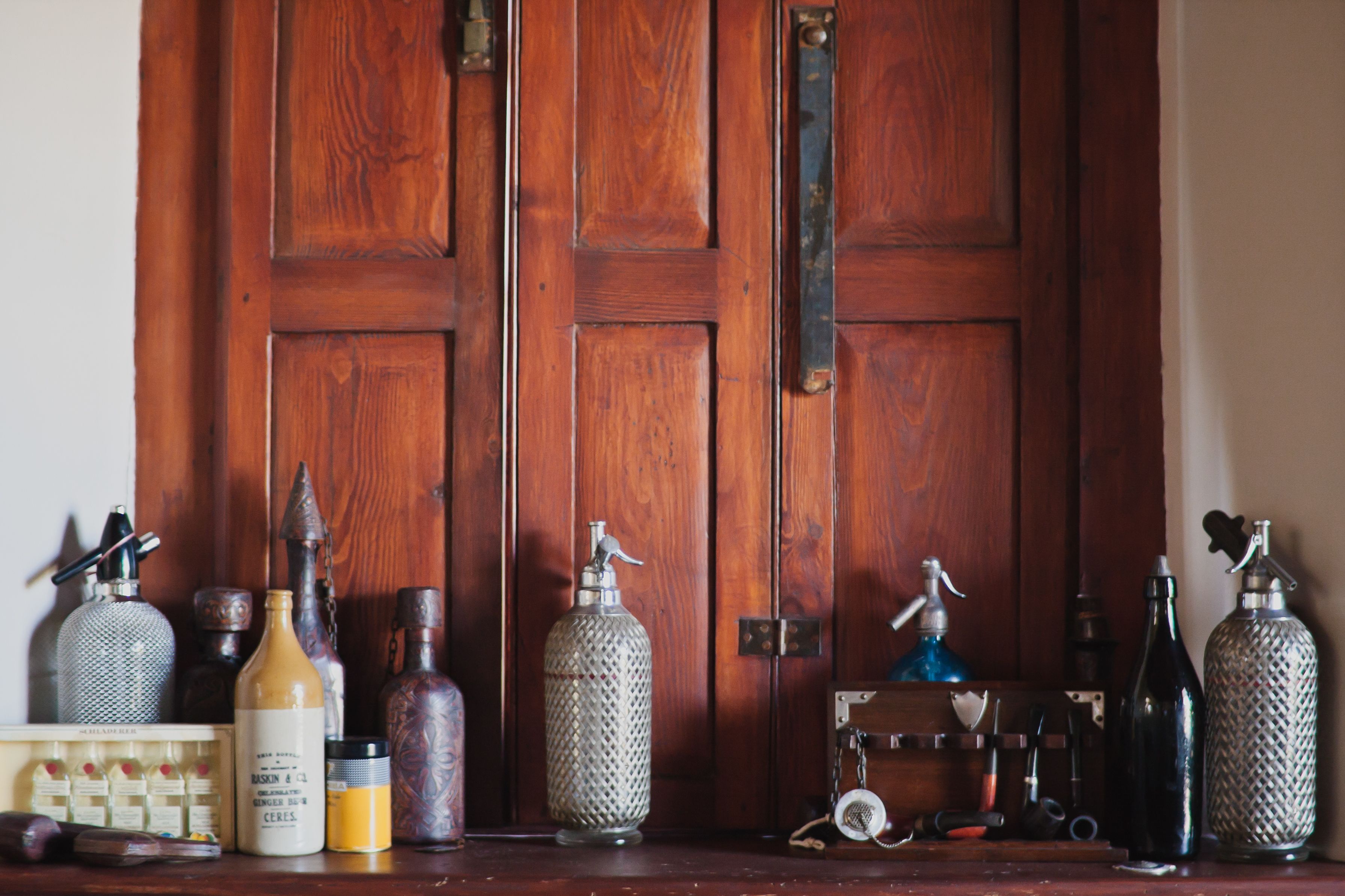 Uma porta de madeira com vários frascos e recipientes sobre uma mesa em frente.