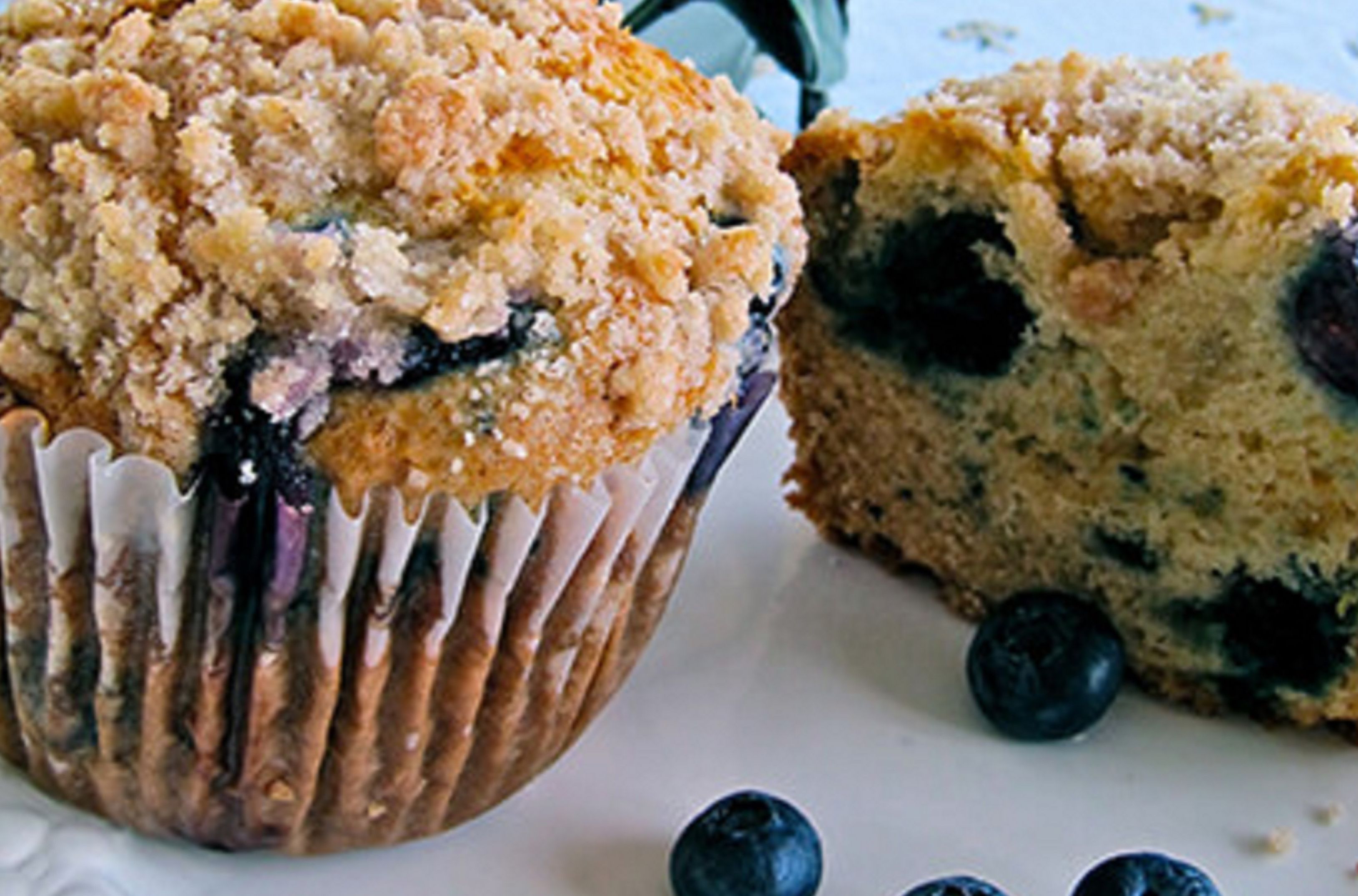 A muffin with blueberries and a crumbly topping.