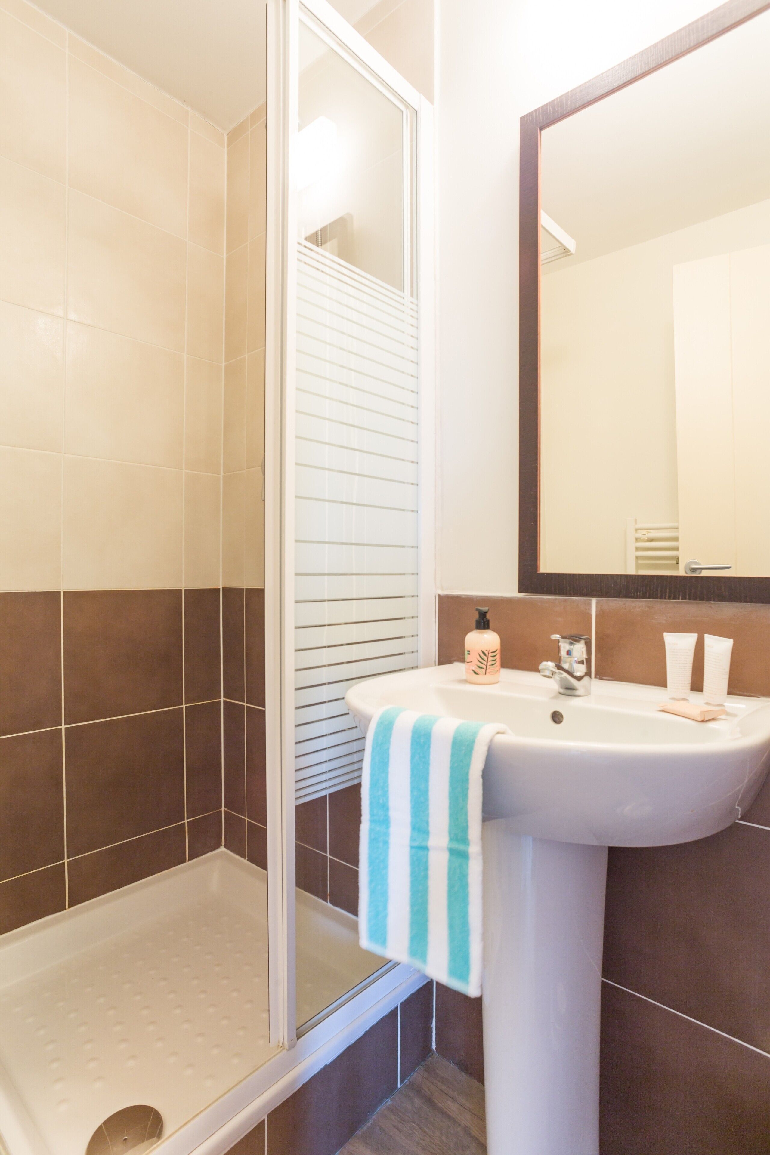 A bathroom with a shower, sink, and mirror.