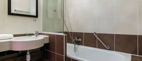 A bathroom with a sink, mirror, and bathtub.