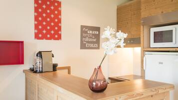 A kitchen with wooden cabinets, a microwave, and a coffee machine on the counter.
