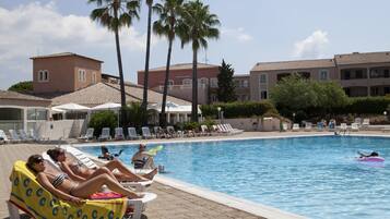 Een buitenzwembad, parasols voor strand/zwembad