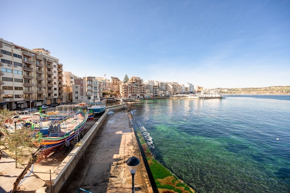 A waterfront cityscape with buildings, boats, and a clear blue sea. - Gillieru Harbour Hotel (St. Paul's Bay)
